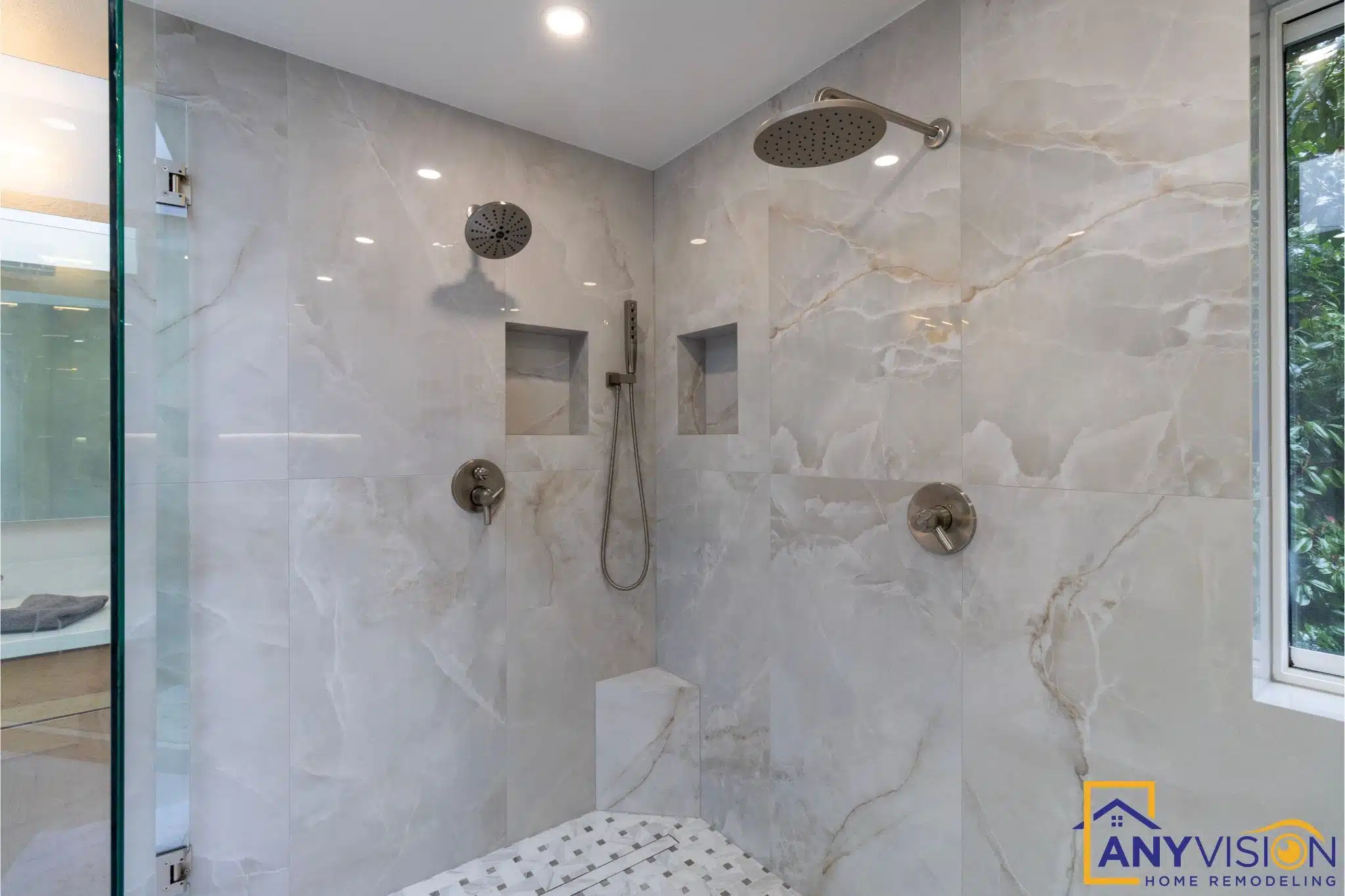 Walk-in shower with dual controls and large-format stone tile