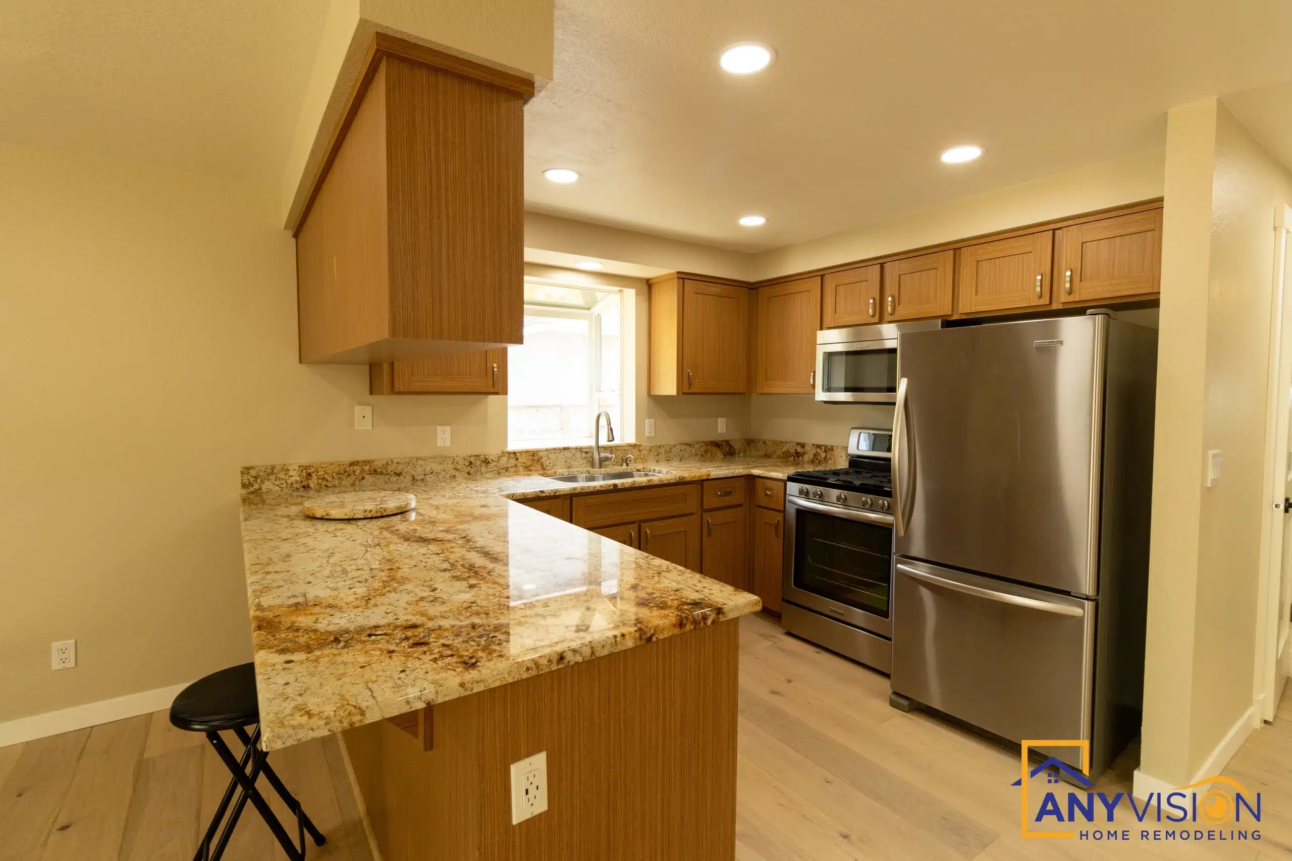 Renovated kitchen with a granite island and stainless appliances in a Mill Creek whole-home remodel